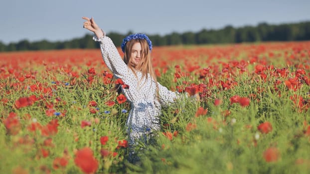 Ukrainian girl walking through a red poppy field
