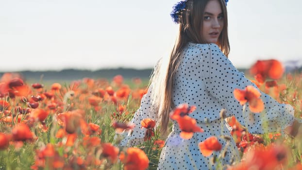 Ukrainian girl walking through a red poppy field