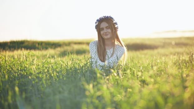 A young Ukrainian girl poses in a young wheat field