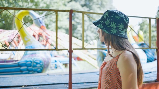 A girl looks at a working ride in a children's park