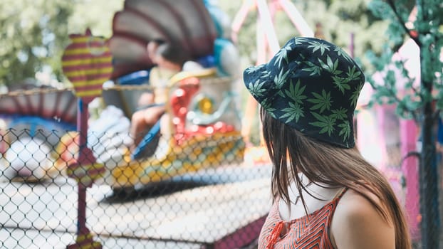 A girl looks at a working ride in a children's park