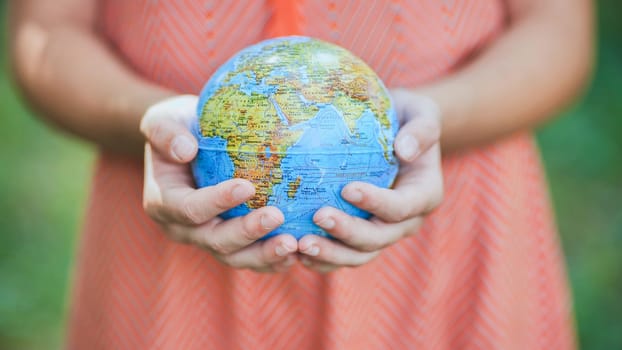 The little one is holding a geographic globe