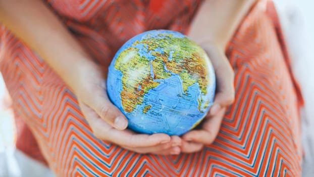 The little one is holding a geographic globe