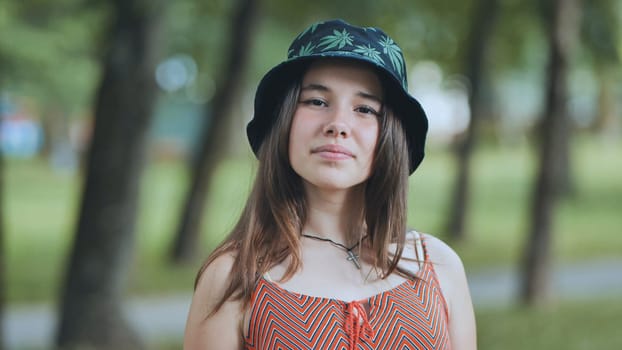 Portrait of a teenage girl in a panama hat in a park in the summer