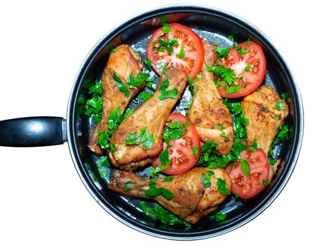 Baked chicken legs in a pan. Cooked chicken legs are decorated with tomatoes and greens.