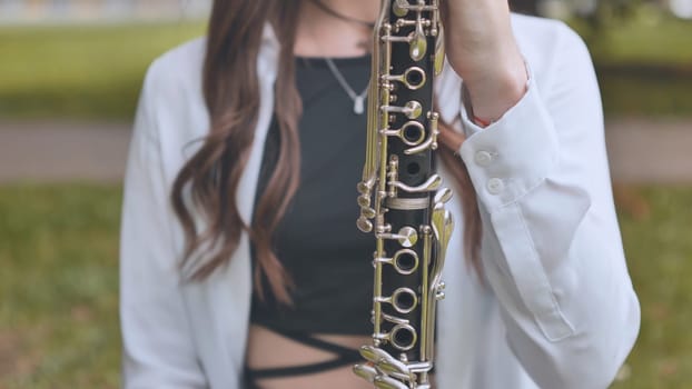 The girl runs her hands over her favorite clarinet