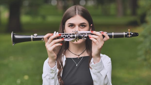 A young Georgian girl holds a clarinet in front of her face