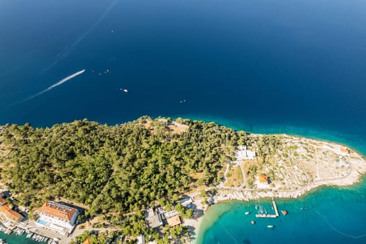 Croatia's Makarska boasts breathtaking panoramas of sea from its elevated vantage points. Houses along coastline provide charming backdrop against blue sea.