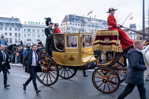 Copenhagen, Denmark - January 04, 2024: Queen Margrethe in her 24-carat golden coach is escorted by the Guard Hussar Regiment on the way from Christiansborg Palace to Amalienborg Palacce