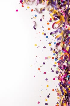 Colorful ribbons and confetti on a white background symbolizing celebration.