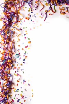 Colorful ribbons and confetti on a white background symbolizing celebration.