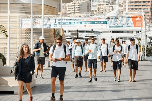 Monaco, Monte-Carlo, 18 October 2022: a group of yachtsmen participating in the upcoming sailing race goes to the yacht club, teams from different countries, the World Championship of J70 class. High quality photo