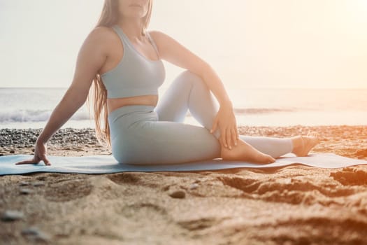 Middle aged well looking woman with black hair doing Pilates with the ring on the yoga mat near the sea on the pebble beach. Female fitness yoga concept. Healthy lifestyle, harmony and meditation.