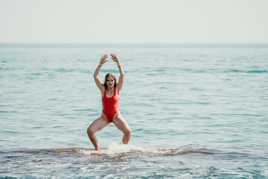 Woman sea yoga. Back view of free calm happy satisfied woman with long hair standing on top rock with yoga position against of sky by the sea. Healthy lifestyle outdoors in nature, fitness concept.