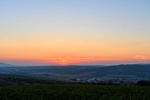 Landscape at twilight with red sky. Romantic sunset with red clouds. Countryside during the blush of dawn.