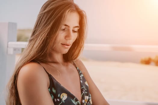 Happy woman portrait in cafe. Boho chic fashion style. Outdoor photo of young happy woman with long hair, sunny weather outdoors sitting in modern cafe