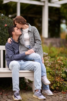 lovely young couple kissing outdoors in autumn. Loving couple walking in nature. Autumn mood. Happy man and woman hugging and kissing in autumn. Love. Fashionable couple outdoors. Fashion, people and lifestyle. Stylish couple in autumn outfit.