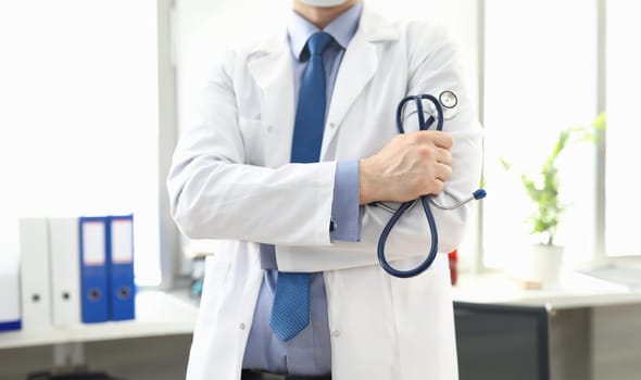 Doctor standing in office with stethoscope in his hand. Platform for online consultation with doctors. Family doctor appointment online. Pandemic disease prevention. Elucidation medical history