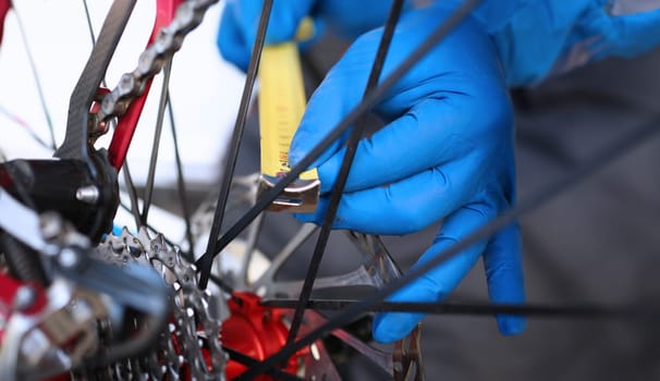 Hands measure with tape measure in bicycle wheel. Man is repairing bicycle wheel. Mechanical part bike. Diagnostics and assembly. Adjustment bicycle mechanism. Visit bicycle service