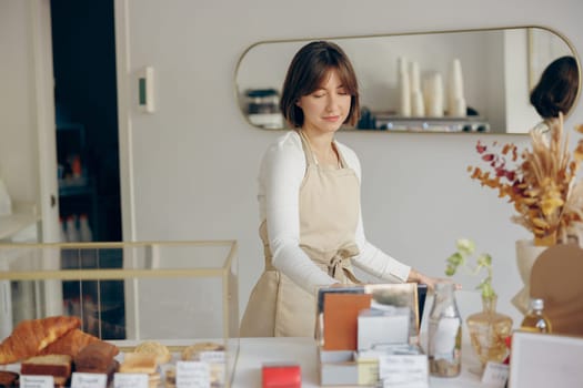 Professional barista standing at the counter in coffee shop and takes orders. High quality photo