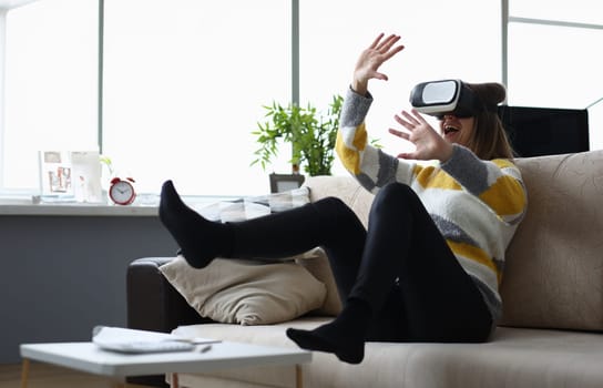 Girl having fun at home with virtual glasses. Reality is transmitted to man through his sensations sight and hearing. Girl reacts fun to virtual reality in game. Positive emotions and joy