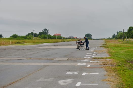 A team of videographers utilizes modern filming equipment while incorporating innovative accessibility tools, including the use of wheelchairs as aids, showcasing a creative and inclusive approach to video production.