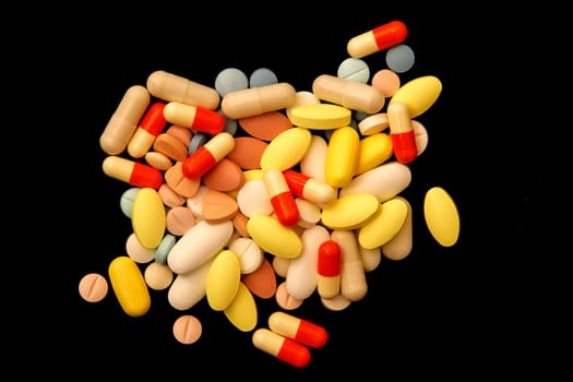 Many different colorful medications and pills. A pile of various multicolored drugs.