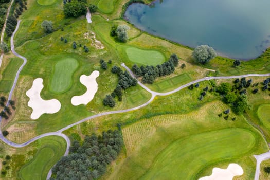 Landscape in golf course and water in lake or lakeside in aerial view. Design for golfers to play games, sports, and outdoor recreation activities.