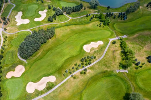 Landscape in a golf course an aerial view of a green field, lake, lawn, and grass.