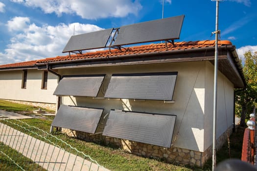 A new modern solar water heater was installed on the wall and roof of a house for heating of water. 