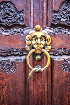 Door knocker. Vintage design knocker on the wooden doors for knocking. Vertical view