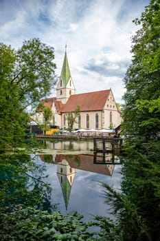 Reflection of Blaubeuren Abbey seen from Blautopf in Blaubeuren, Germany