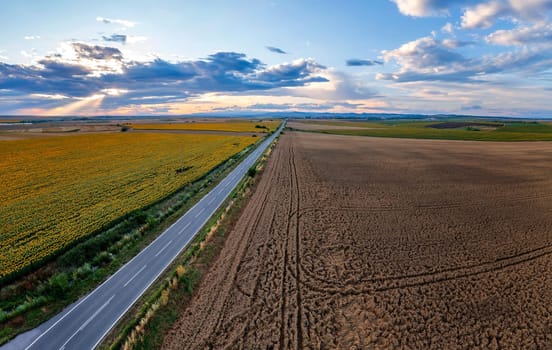 aerial view of a rural landscape with a asphalt road, against the sunset