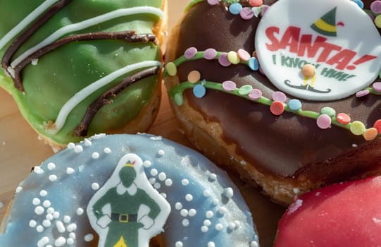 Close-up of Four glazed Doughnuts placed on wooden cutting board. The concept of delicious delicious amazing glazed donuts, Space for text, Selective Focus.