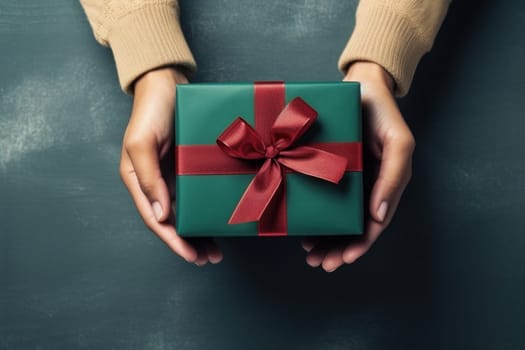Hands holding dark green gift box and red ribbon top view, Christmas concept. Generative AI.