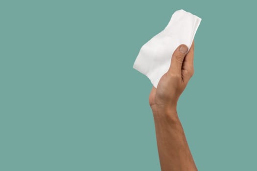 Male hand holding white cleaning cloth on green background. High quality photo