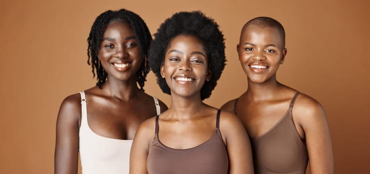 Face, beauty and wellness with black woman friends in studio on a brown background for natural aesthetic. Portrait, skincare and smile with a group of african people looking happy or satisfied.