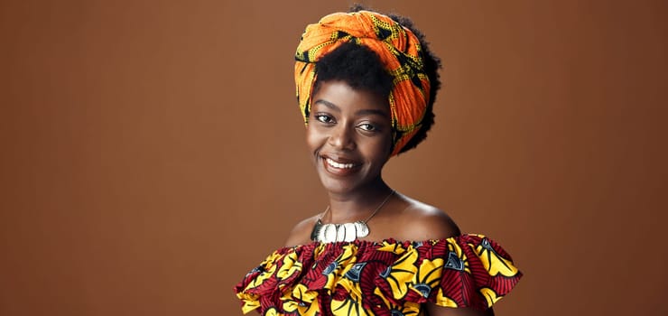 Wrap, fashion or face of happy black woman in studio on a brown background for trendy style. Smile, African or model with confidence, pride or afro posing in culture, clothes or traditional outfit.