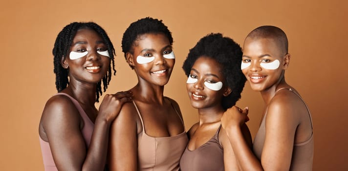 Face, happy or black women with eye patch for skincare or beauty isolated on brown background. Studio, smile or African models with facial collagen pads, dermatology product or anti aging cosmetics.
