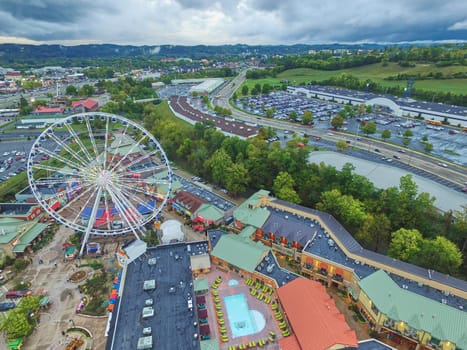 Aerial view of vibrant entertainment complex with Ferris wheel in Pidgeon Forge, Tennessee, late afternoon ambiance with impending weather