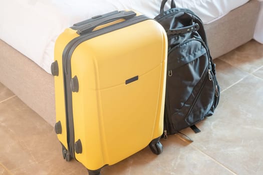 yellow suitcases on white wall background in hotel room near bed
