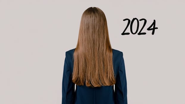 business woman with the new year 2024 . Businesswoman look at 2024 black color letter over grey background, Business happy new year 2024 cover concept. High quality image