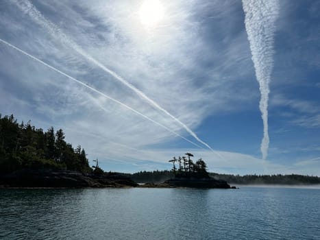 Scenic view of an island along the Central Coast of British Columbia with blue skies and streaky clouds. Near Stryker Island, British Columbia, Canada