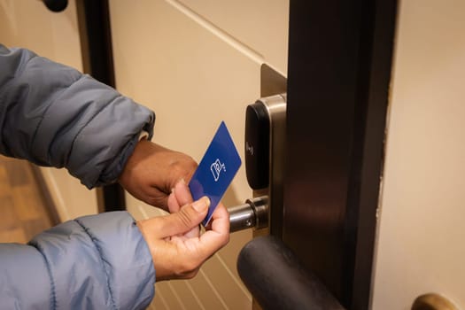 Woman hand using electronic smart key card to unlock door in hotel or house. Digital lock, door access control, contactless concept. Closeup, copy space.