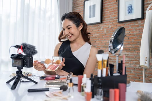 Asian Woman influencer shoot live streaming vlog video review makeup uttermost social media or blog. Happy young girl with cosmetics studio lighting for marketing recording session broadcasting online