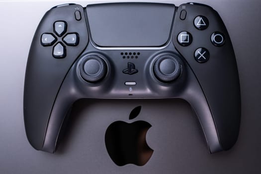 BERLIN , GERMANY - JANUARY 14 2024: A detailed view of a video game controller, suitable for gaming on Apple MacBook Pro Space Black.