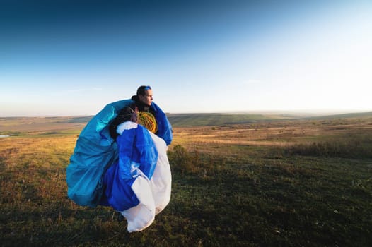 The guy holds the lines of a paraglider in his hands close-up. A male paraglider carries a paraglider to a pasture. The pilot checks the paraglider's lines to ensure they are not damaged.