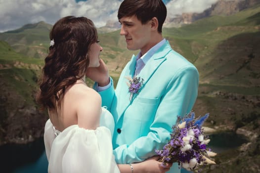 Love, wedding and married couple kissing by the lake outdoors in honor of their romantic marriage. Water, summer, mountains or a kiss.