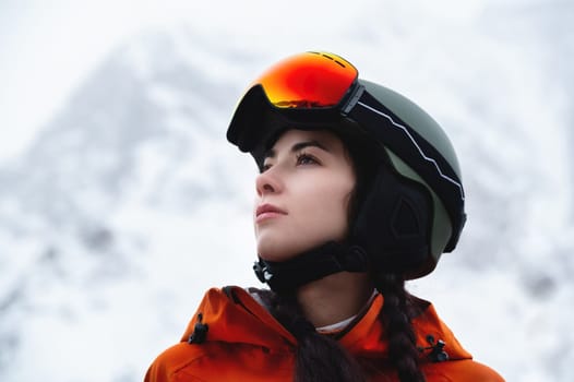 Portrait of a woman in the Alps. Young beautiful caucasian woman in ski goggles looking at the camera with a sexy look.