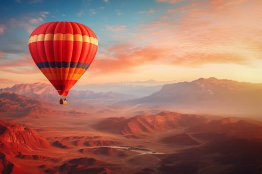 A colorful hot air balloon floats in sky over a desert mountain landscape at sunset with orange and blue skies in the background. Travel journey adventure beauty of nature concept